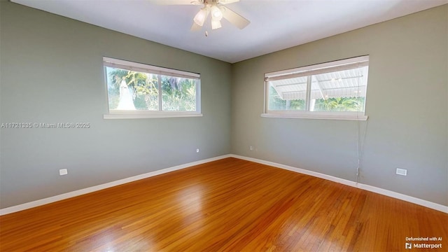 empty room featuring ceiling fan, wood-type flooring, and a healthy amount of sunlight