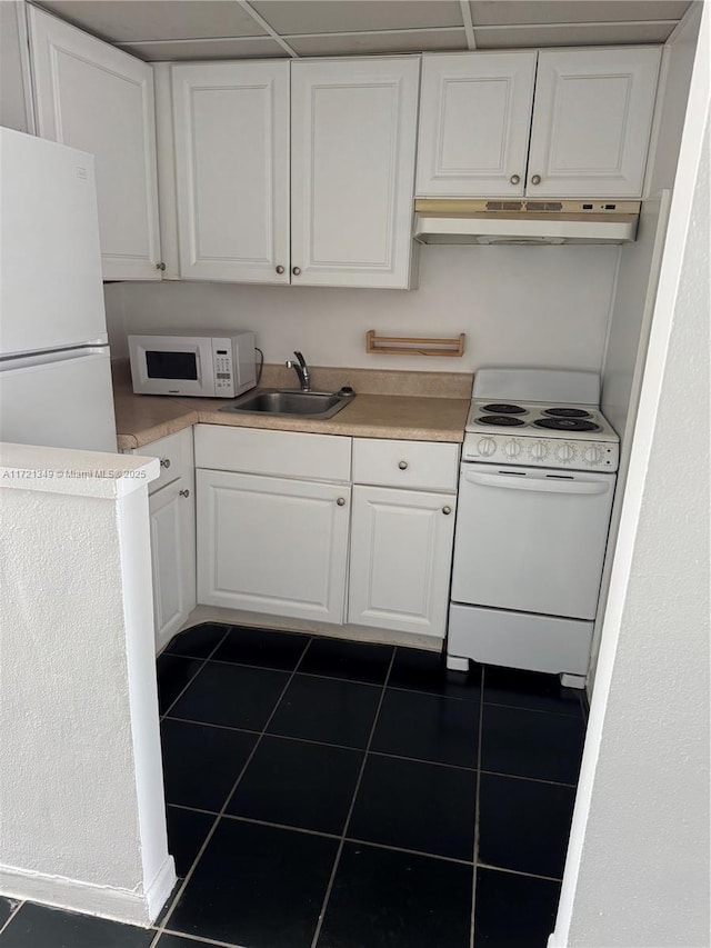 kitchen featuring white cabinetry, sink, dark tile patterned floors, and white appliances