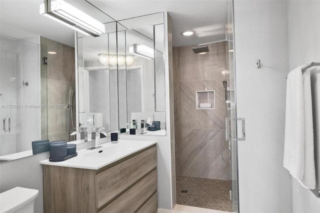 bathroom with a shower with door, toilet, and vanity