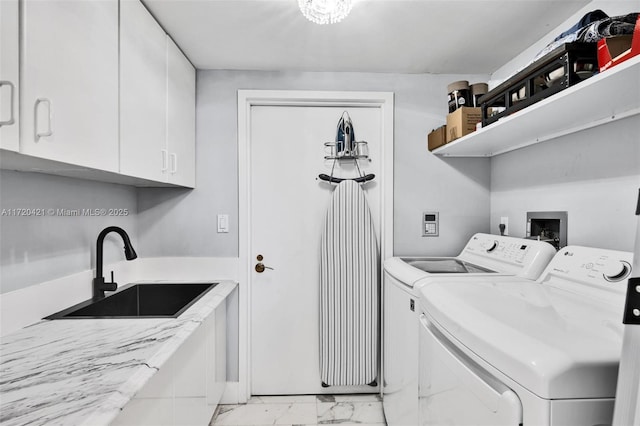 washroom with sink, washer and clothes dryer, and cabinets