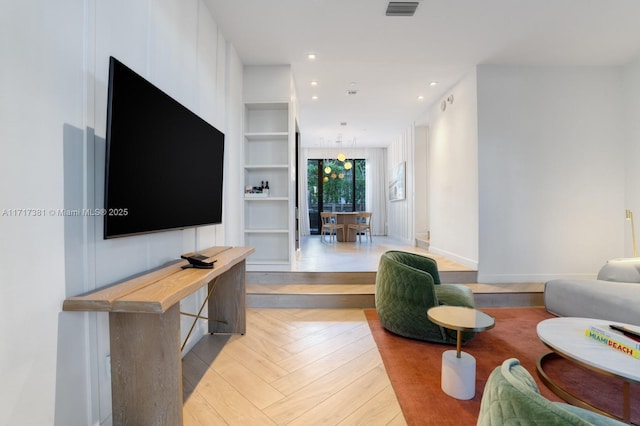 living room featuring light parquet floors and built in features