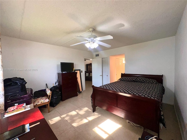 bedroom featuring light tile patterned floors, a textured ceiling, and ceiling fan