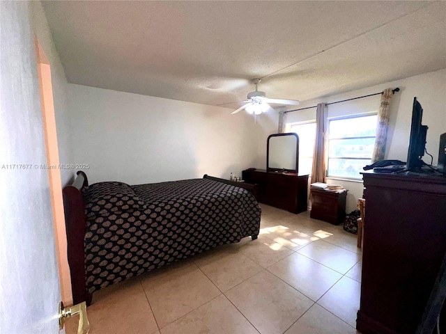 tiled bedroom featuring ceiling fan and a textured ceiling