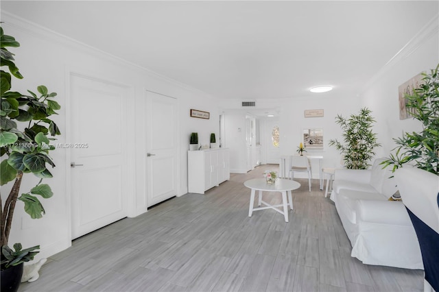 living room with light hardwood / wood-style flooring and crown molding