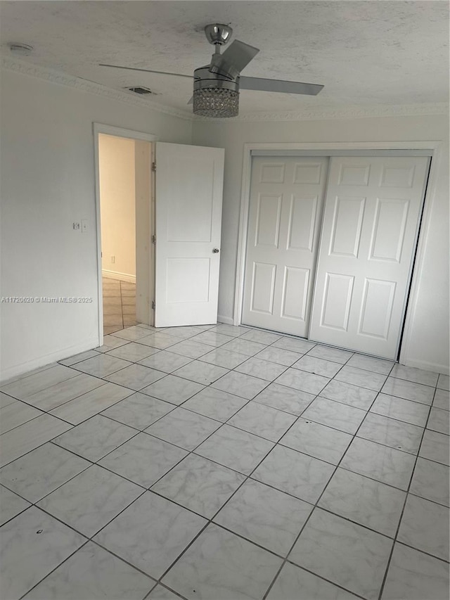 unfurnished bedroom featuring ceiling fan and a closet