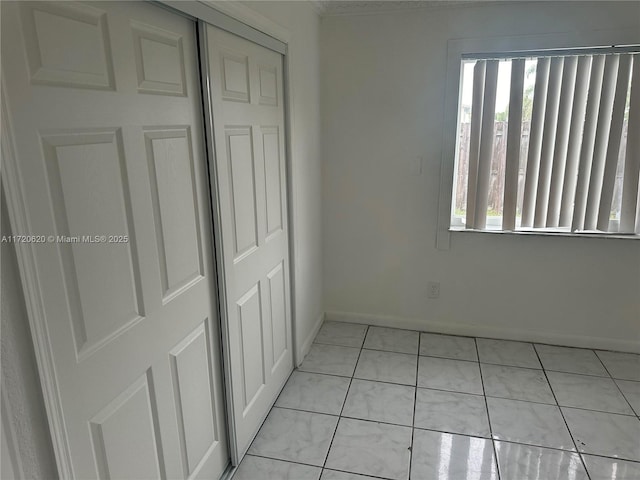 unfurnished bedroom featuring light tile patterned flooring and a closet