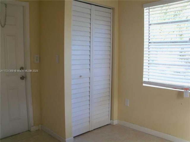 unfurnished bedroom featuring multiple windows and a closet