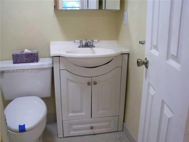 bathroom with tile patterned flooring, vanity, and toilet