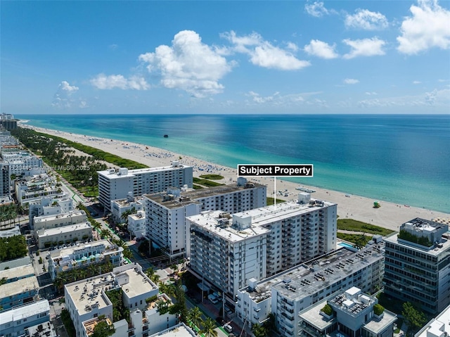 birds eye view of property featuring a water view and a beach view