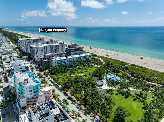 drone / aerial view featuring a water view and a beach view