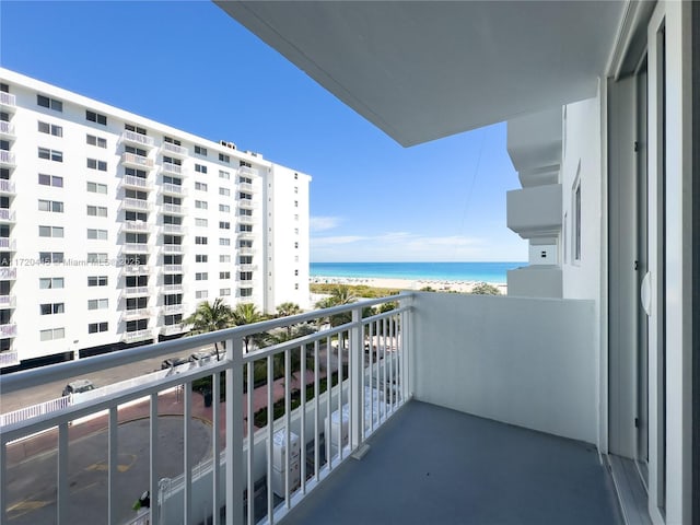 balcony featuring a water view and a beach view