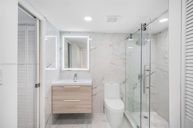 bathroom featuring vanity, toilet, a shower with door, and tile walls