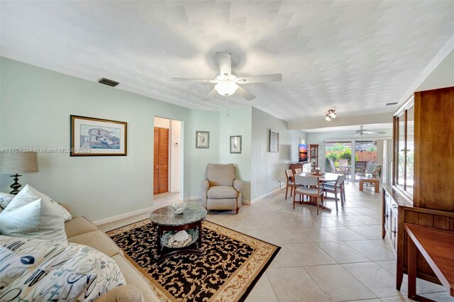 living room with ceiling fan and light tile patterned floors