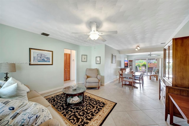 living room with light tile patterned floors, a textured ceiling, and ceiling fan