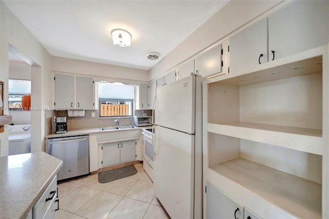 kitchen featuring sink, light tile patterned floors, white appliances, washer / clothes dryer, and backsplash