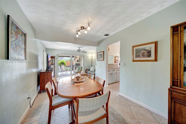 tiled dining area with ceiling fan and track lighting