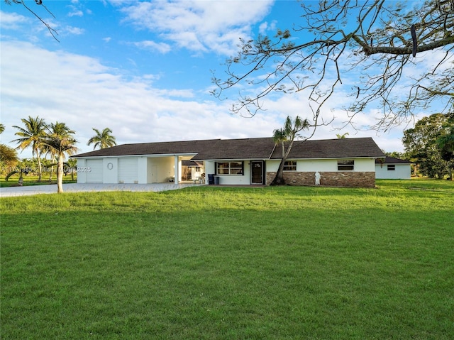 ranch-style house featuring a garage and a front lawn