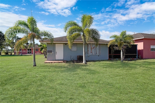 back of property featuring a lawn and cooling unit