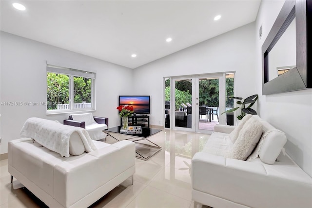 living room featuring french doors, lofted ceiling, and light tile patterned flooring