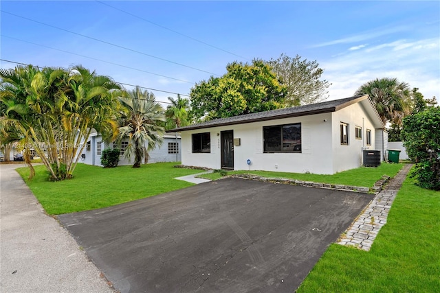 ranch-style home featuring central AC unit and a front lawn