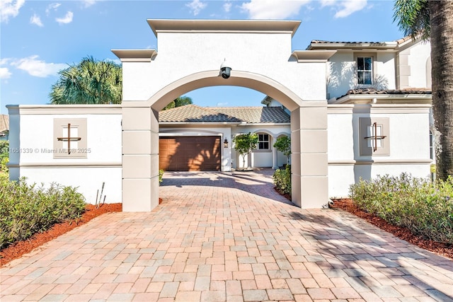 view of front of property featuring decorative driveway, a tile roof, and stucco siding