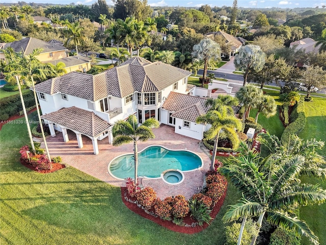 view of pool with a pool with connected hot tub, a patio area, and a yard