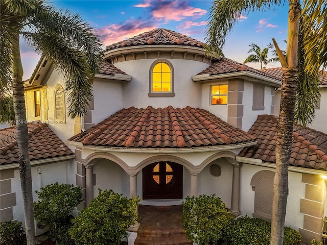 mediterranean / spanish-style house with a tile roof and stucco siding