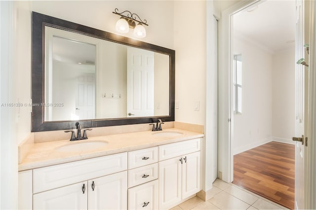 bathroom with double vanity, ornamental molding, a sink, and tile patterned floors