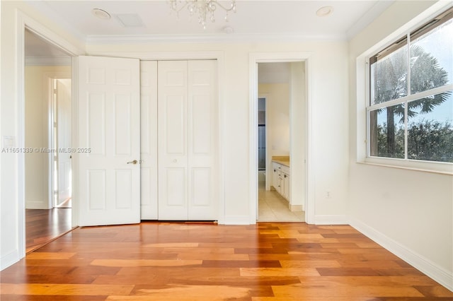14403 S Jockey Cir S, Davie, FL 33330 - unfurnished bedroom featuring light wood-style flooring, ornamental molding, a closet, and a chandelier