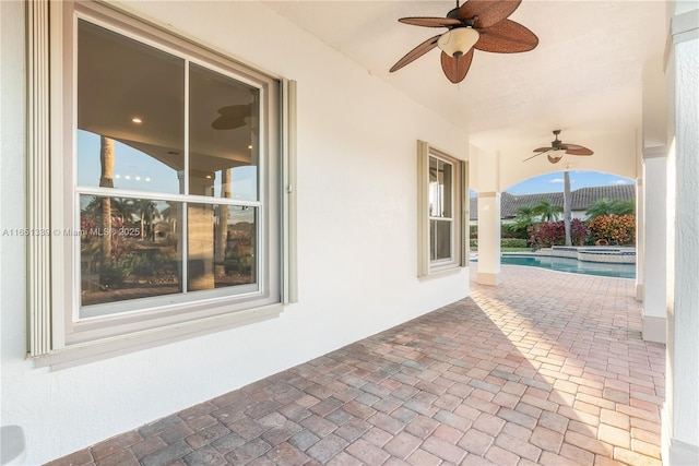 view of patio / terrace featuring a pool with connected hot tub, ceiling fan, and fence