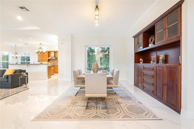 dining room with a wealth of natural light, marble finish floor, visible vents, and a notable chandelier