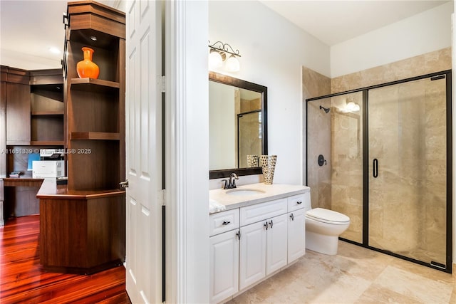 full bath featuring toilet, a stall shower, and vanity