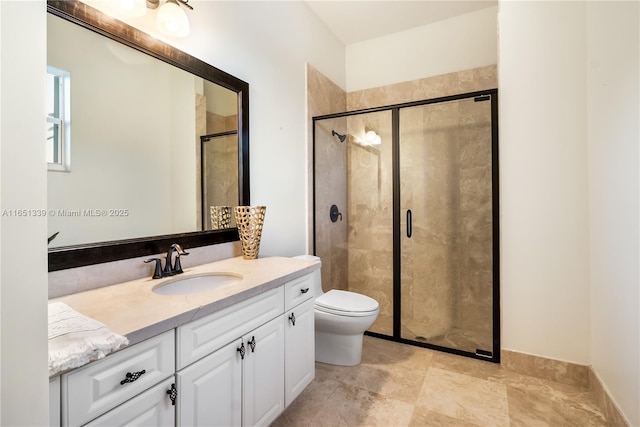 bathroom with toilet, a shower stall, and vanity