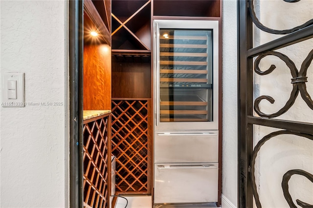 wine room with wine cooler and a textured wall