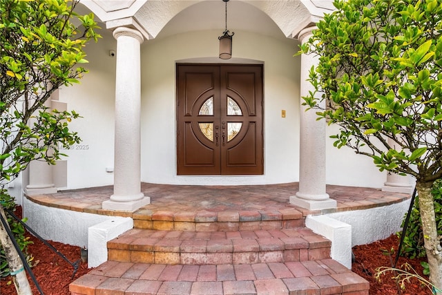 entrance to property featuring stucco siding