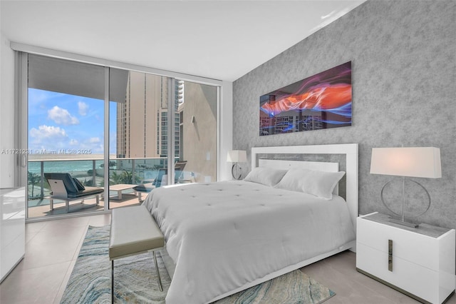 bedroom featuring multiple windows, tile patterned flooring, access to outside, and expansive windows