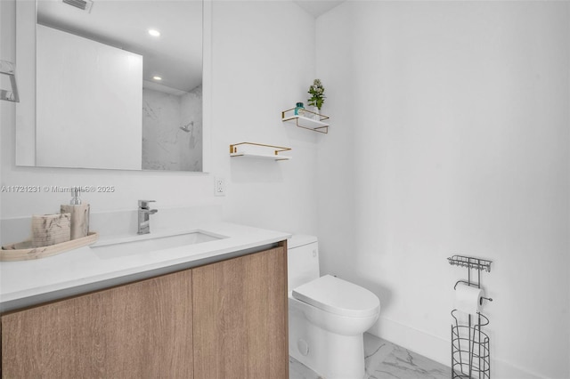 bathroom featuring a shower, vanity, and toilet