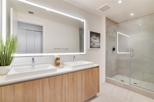 bathroom featuring vanity and a shower with door