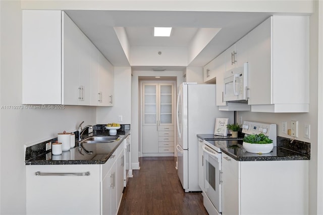 kitchen featuring a tray ceiling, sink, white cabinets, and white appliances