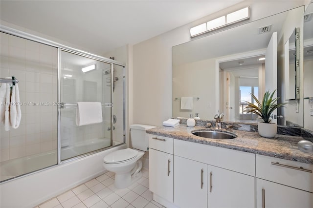 full bathroom with tile patterned flooring, vanity, toilet, and bath / shower combo with glass door