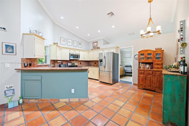 kitchen with backsplash, kitchen peninsula, vaulted ceiling, decorative light fixtures, and appliances with stainless steel finishes