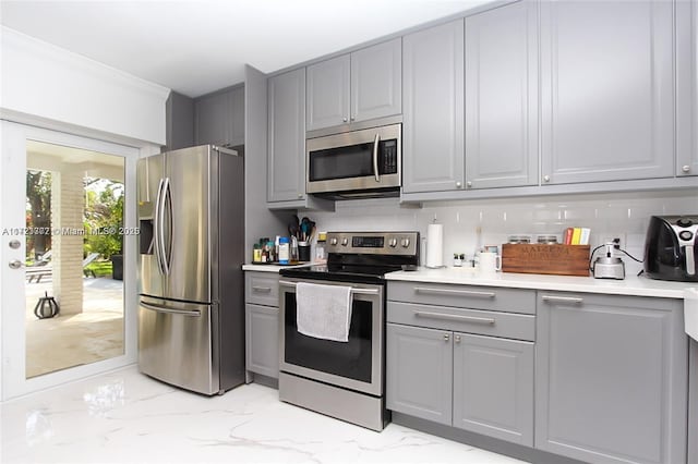 kitchen with backsplash, gray cabinets, and appliances with stainless steel finishes