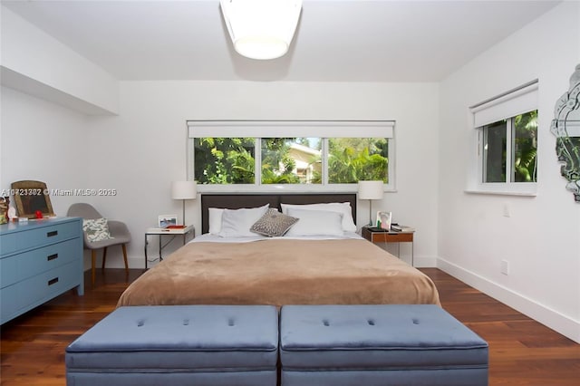 bedroom with dark hardwood / wood-style flooring