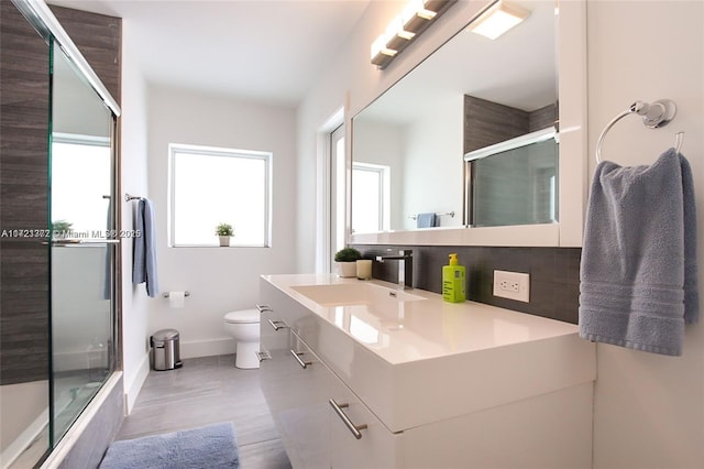 bathroom with decorative backsplash, vanity, and toilet