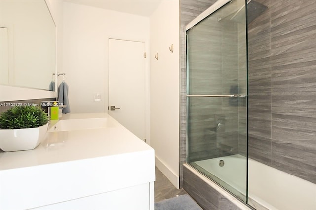 bathroom featuring vanity and shower / bath combination with glass door