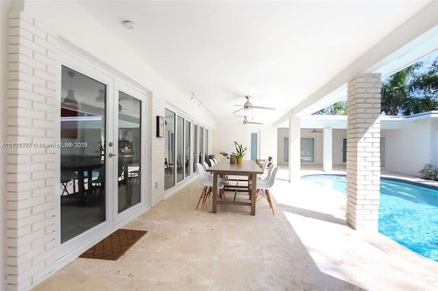 sunroom with ceiling fan and a swimming pool