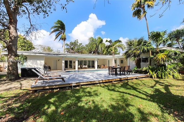 rear view of house featuring a swimming pool side deck, ceiling fan, and a yard