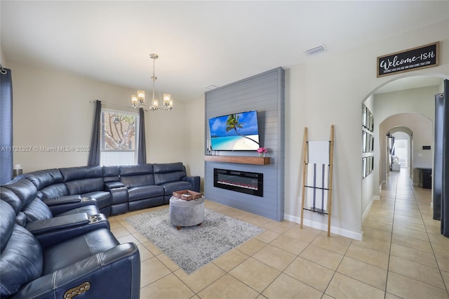 tiled living room with a fireplace and a chandelier