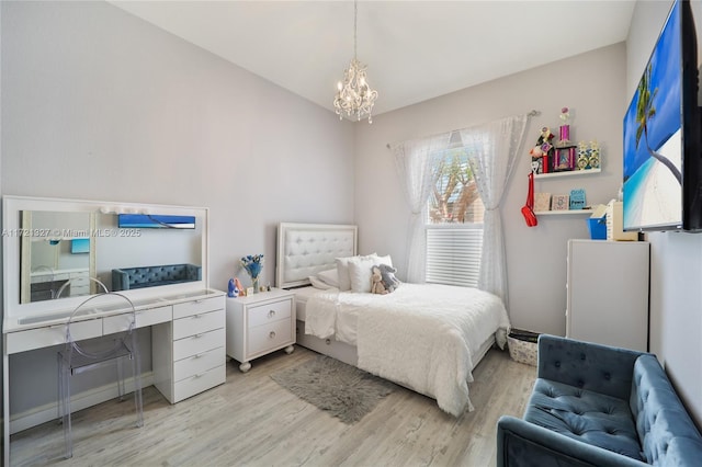 bedroom with light wood-type flooring and an inviting chandelier