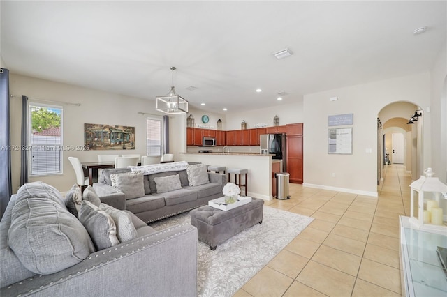 tiled living room with an inviting chandelier